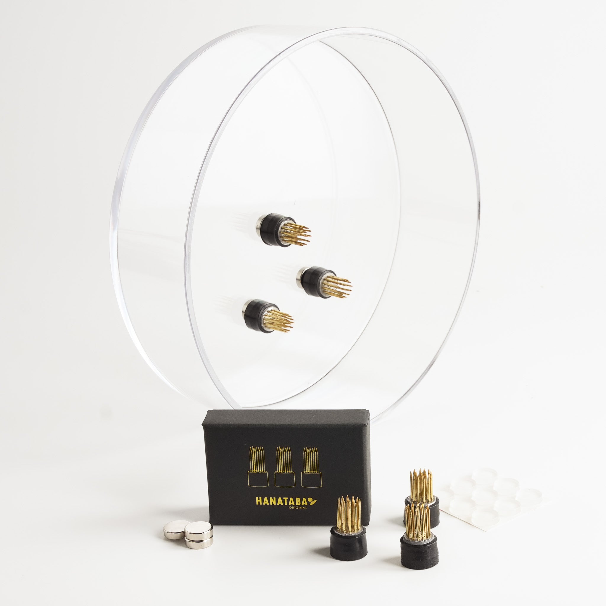 Hanataba magnetic flower frogs attached to a clear acrylic bowl using magnets, with the full set including box, magnets, and silicone pads shown in front.