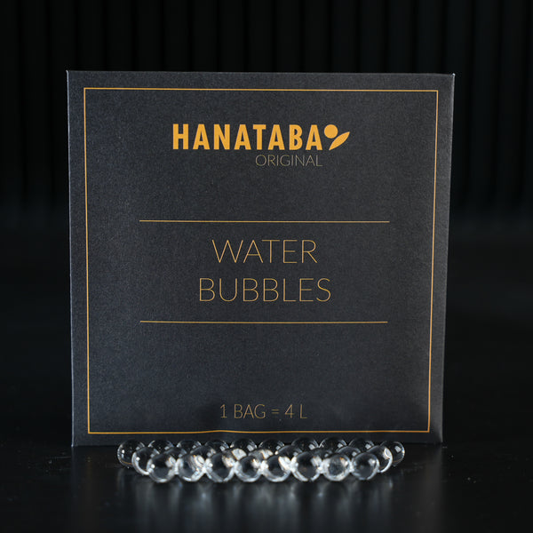 A sophisticated package labeled 'HANATABA Original Water Bubbles' with the text '1 BAG = 4L', accompanied by transparent water bubbles in front, designed for enhancing flower arrangements.