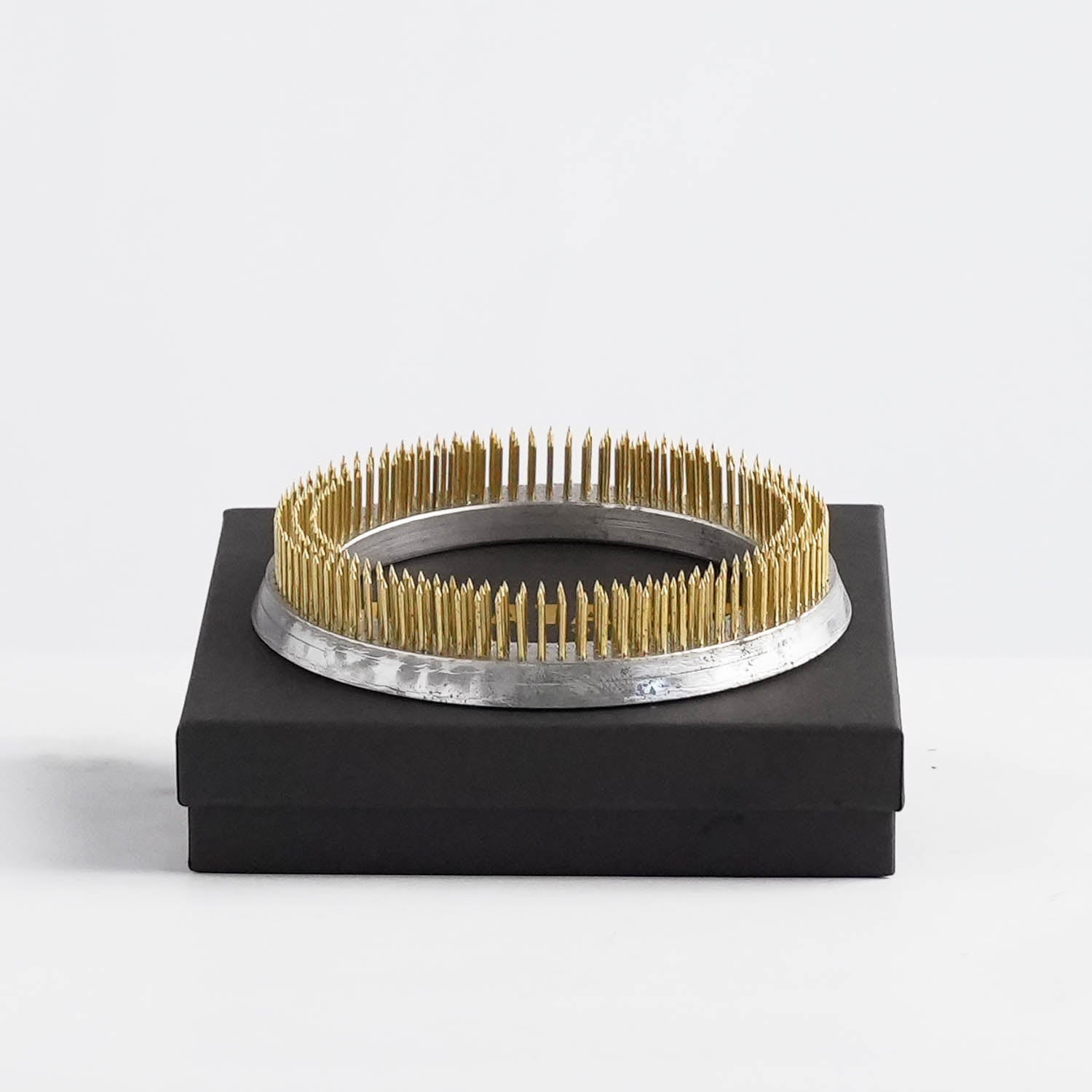 A 120 mm Kenzan flower frog with copper spikes for floral arrangements. The product is shown on top of its black packaging from Hanataba.