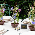 Table setting with floral arrangements in brown ceramic kenzan bowls by Hanataba