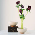 Beige ceramic kenzan 'kobachi' bowl with purple flowers on a white background