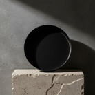 Black metallic plate on a concrete block with a gray concrete background