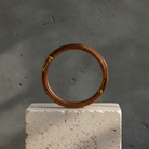 Brown bonsai wire coil on a concrete block with a gray background