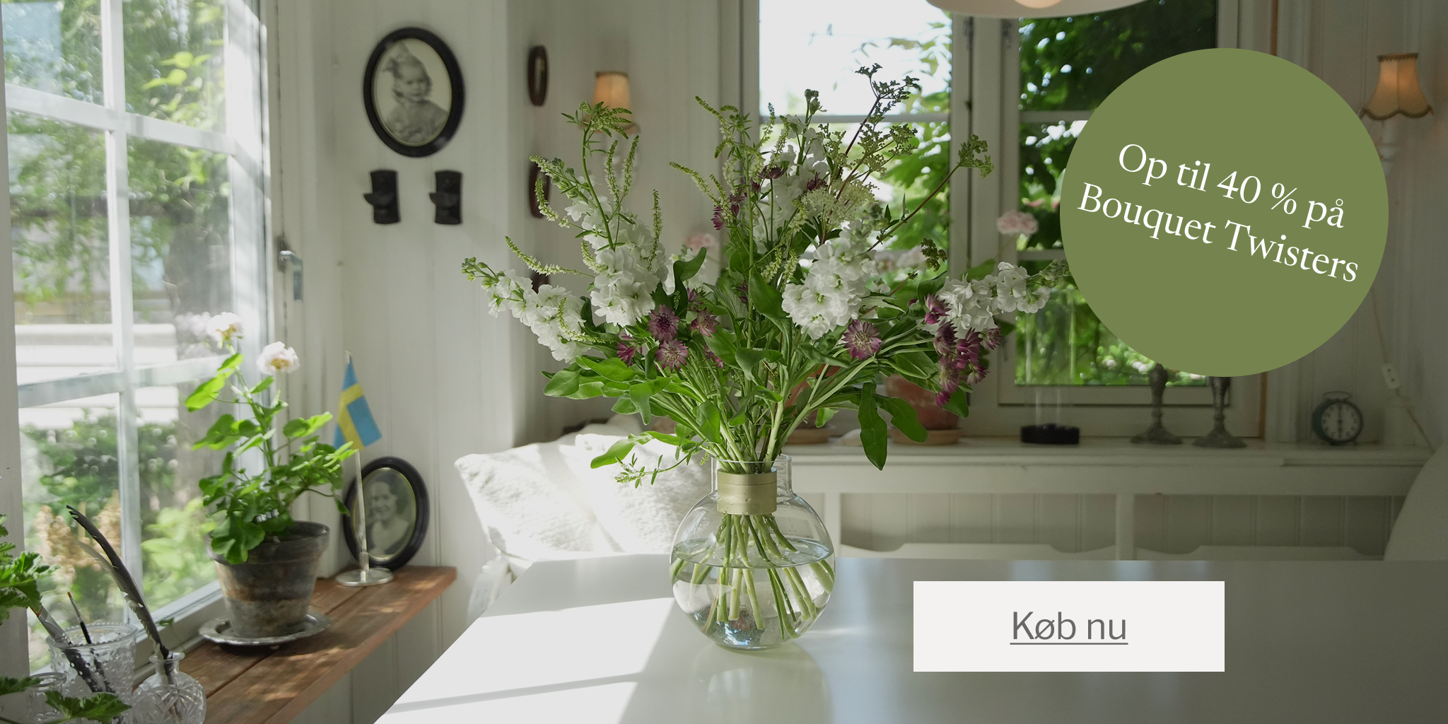 Living room with a vase of flowers, plants, and a promotional banner for Bouquet Twisters.