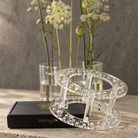 A clear acrylic two-tier stand with a geometric block pattern, displayed on a black Hanataba box with dried flowers in the background.