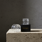 Hanataba Bouquet flower twister in color 'Crystal Clear' with a black paper box, labeled 'Hanataba' standing on a stone piedestal
