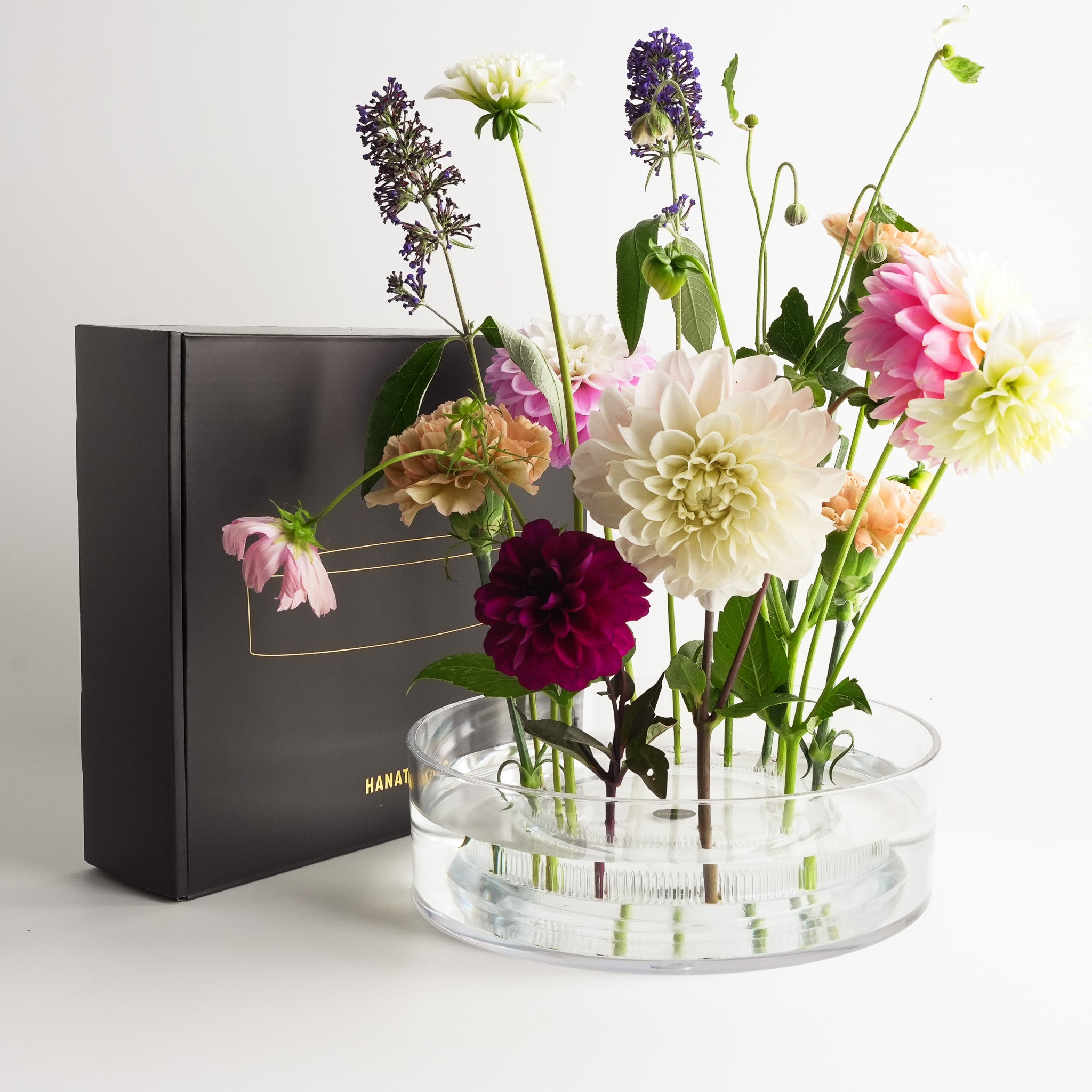 Hanataba Acrylic Cylinder Vase with floral arrangement in front of the black Hanataba gift box, showcasing elegant design and premium presentation.