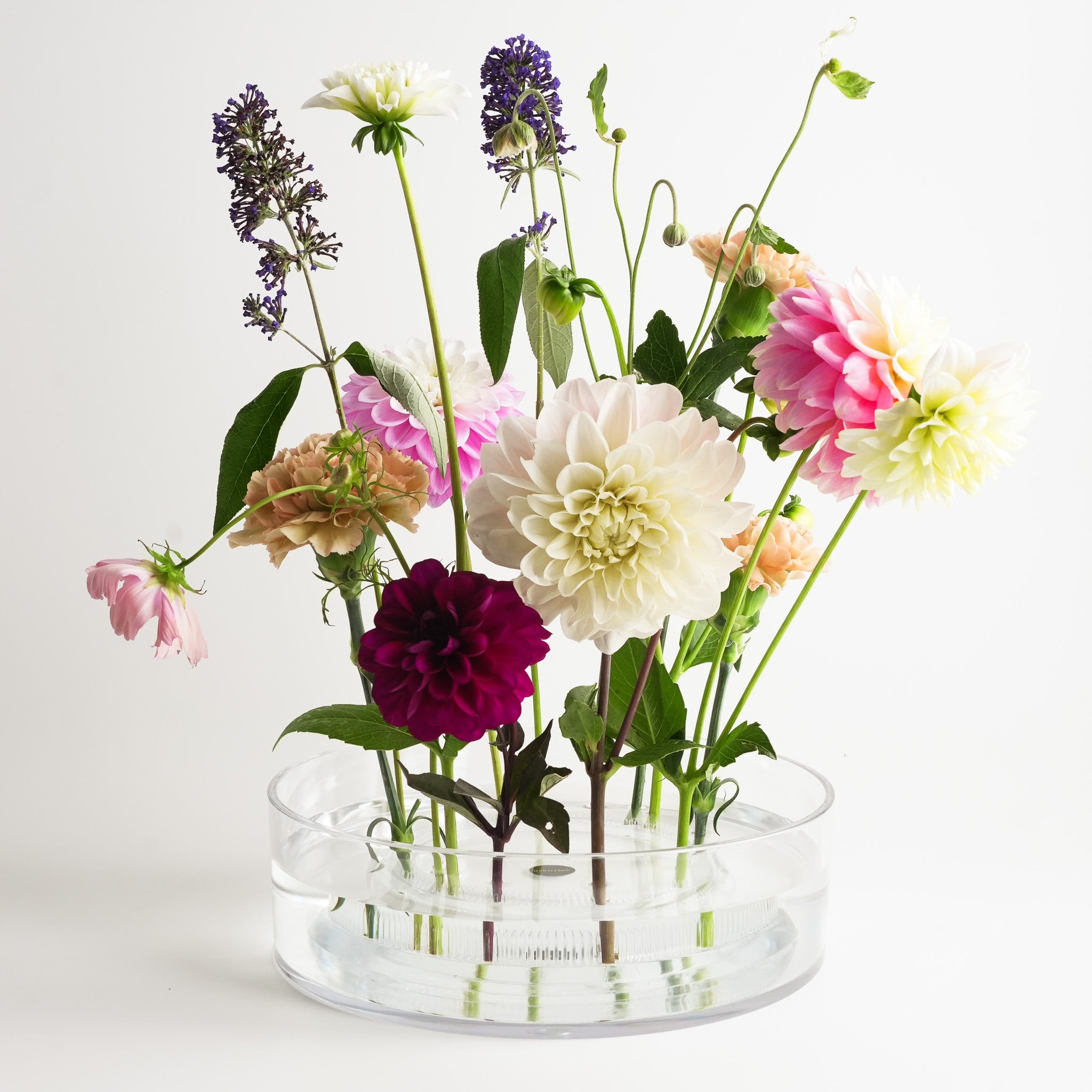Hanataba Acrylic Cylinder Vase displaying a vibrant arrangement of dahlias, carnations, and garden flowers held upright with a Hanataba acrylic kenzan flower frog ring 150 mm.
