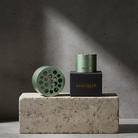 Two green cylindrical Hanataba bouquet flower twisters used for making spiral bouquets at home without experience on a concrete block with a dark background