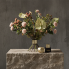 Hanataba Twister flower holder in champagne gold with bouquet of anthurium and soft pink chrysanthemums, product parts displayed on stone pedestal