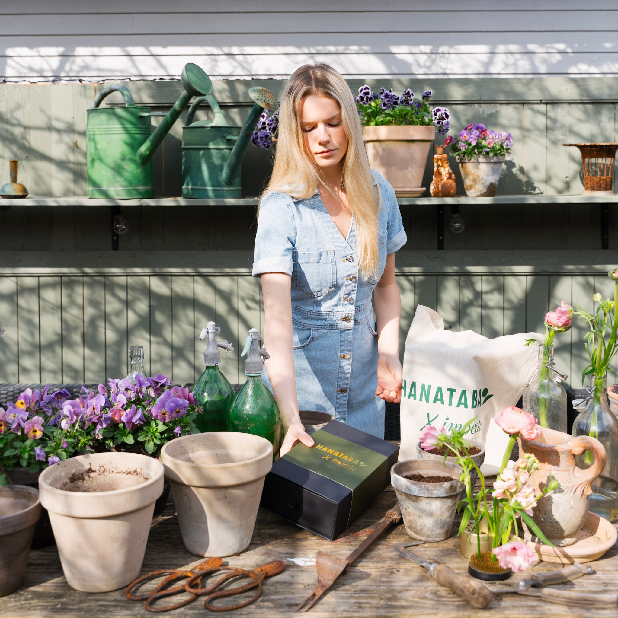 Woman in a greenhouse with gardening supplies and plants