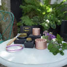 Collection of gardening tools and accessories on a table with a natural background by Hanataba Original