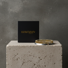 Black box with 'HANATABA' branding and a kenzan ring 120 mm flower frog ring on a concrete block against a gray background