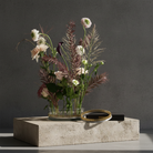 Bouquet of flowers in a glass vase and a kenzan ring 200 mm flower frog ring on a concrete surface with a dark background