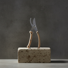 Pruning shears on a concrete block against a dark gray background