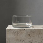 Clear glass bowl on a concrete surface with a gray background