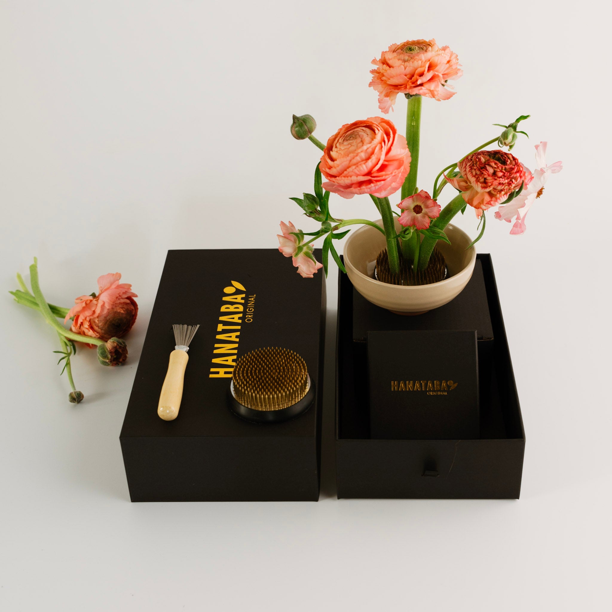 Floral arrangement in a pot with grooming tools and 'HANATABA' branding on a white background