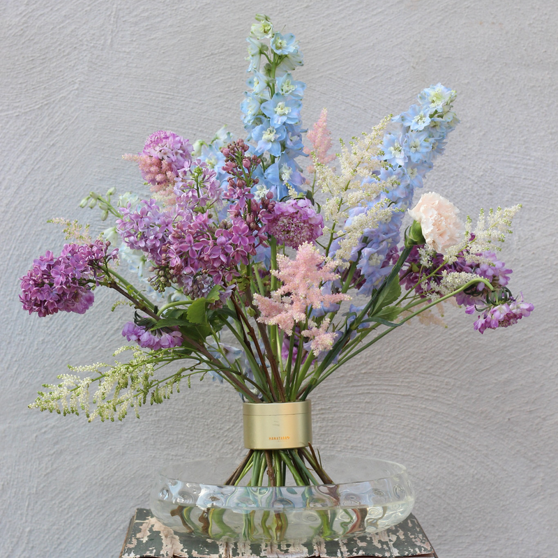 Elegant Ikebana floral arrangement with a variety of pastel-colored blooms, including lilacs and delphiniums, secured by a chic Spiral Stem holder.