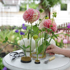 Person arranging dahlias and green flowers on hanataba kenzan flower frog 34 mm, 70 mm and 120 mm ring