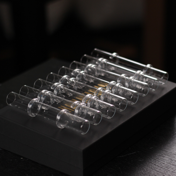 Showcases the Hanataba Flower Flute set, an array of elegant clear glass tubes for floral arrangements, neatly presented on a dark matte presentation box.