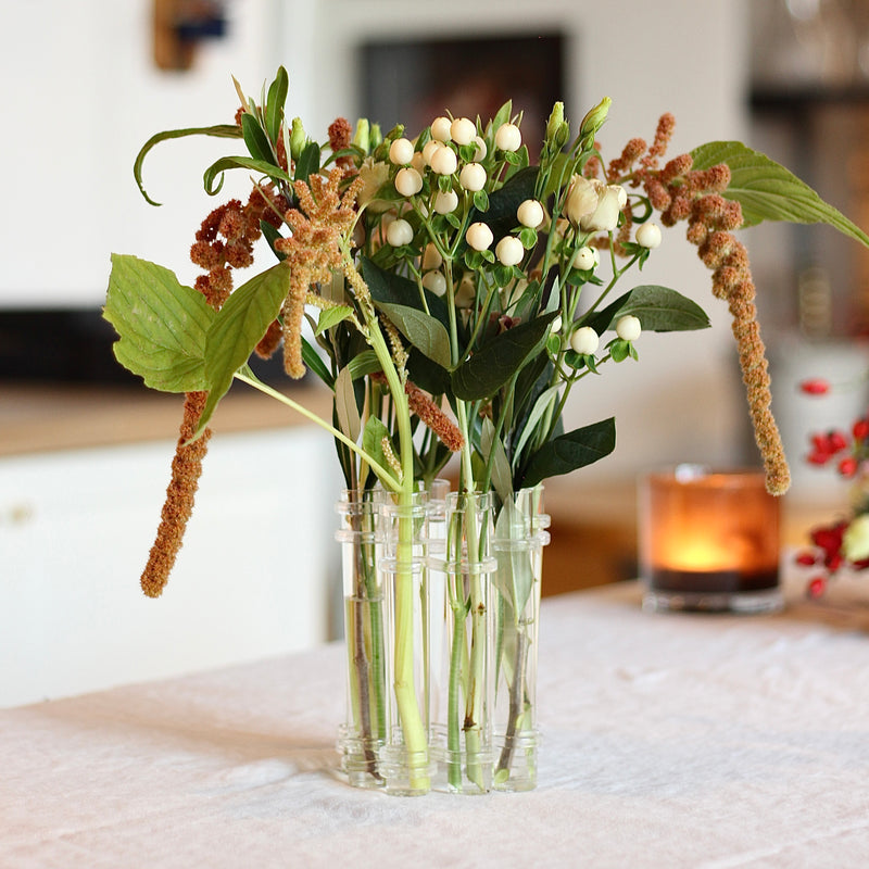 A Flowerflute vase from Hanataba filled with an arrangement of mixed seasonal blooms and foliage.