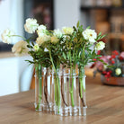 Elegant Flowerflute vase from Hanataba displaying an arrangement of fresh white roses on a wooden tabletop.