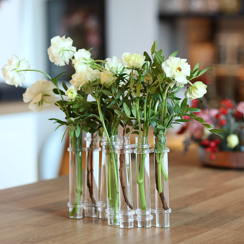 Elegant Flowerflute vase from Hanataba displaying an arrangement of fresh white roses on a wooden tabletop.