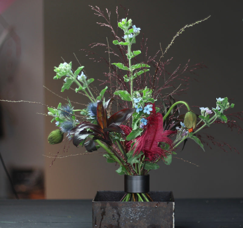 Ikebana arrangement featuring a variety of flowers and foliage secured with a Hanataba pitch black spiral stem holder.