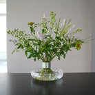 Beautiful pastel-colored spiral bouquet displayed in a clear glass vase with design stem holder.