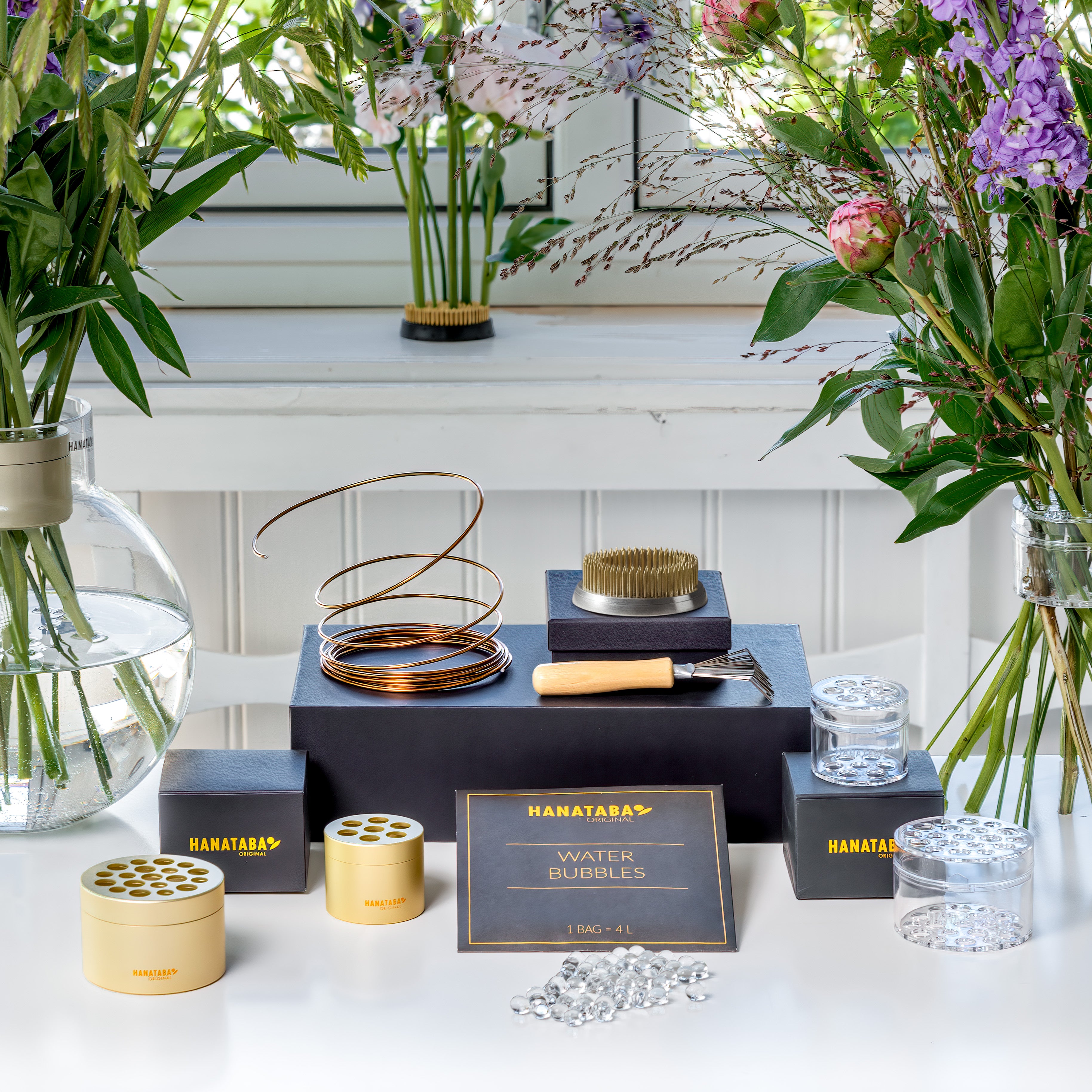 Collection of Hanataba products on a table with flowers in the background