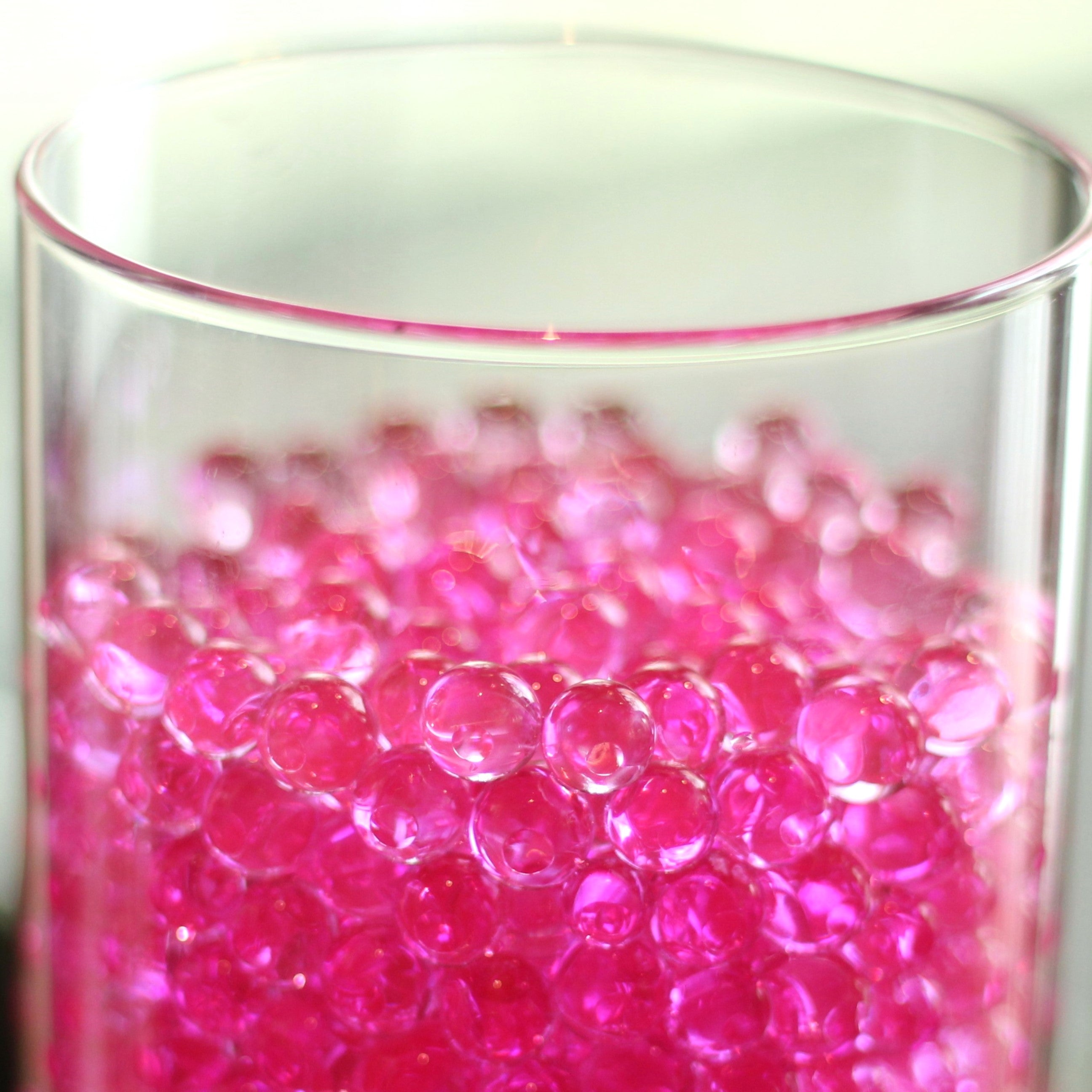 Vibrant pink water bubbles filling a clear glass vase, adding a pop of color for flower arrangement creativity.