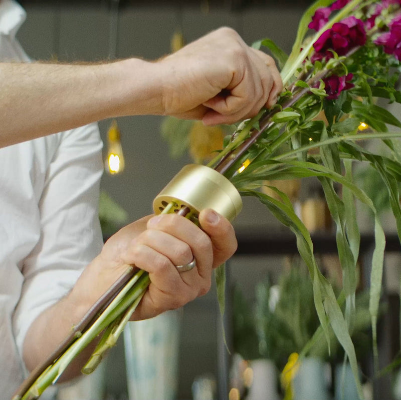 Close-up of hands meticulously fastening stems with a Champagne Gold Hanataba twister.