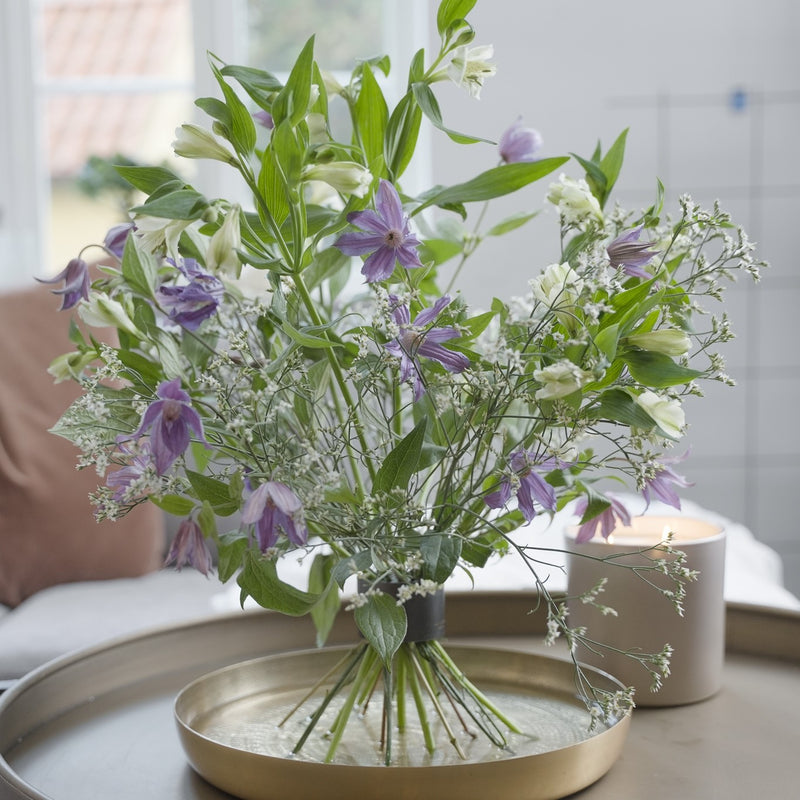 A bouquet of purple and white flowers, including bellflowers and alstroemeria, arranged with a Hanataba Bouquet Twister in Pitch Black.